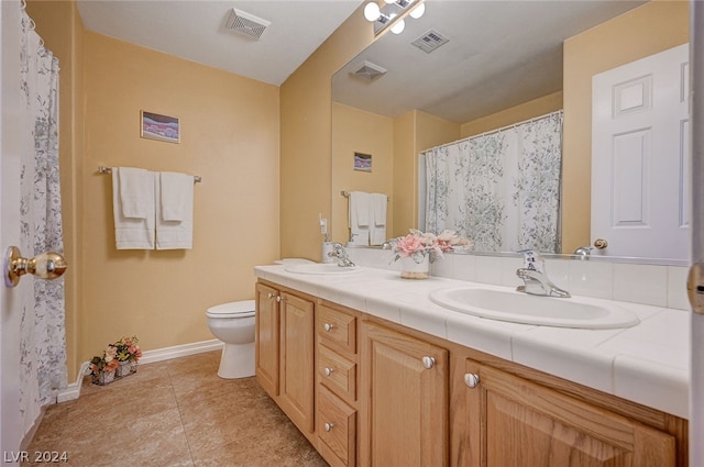 bathroom featuring dual vanity, tile patterned floors, and toilet