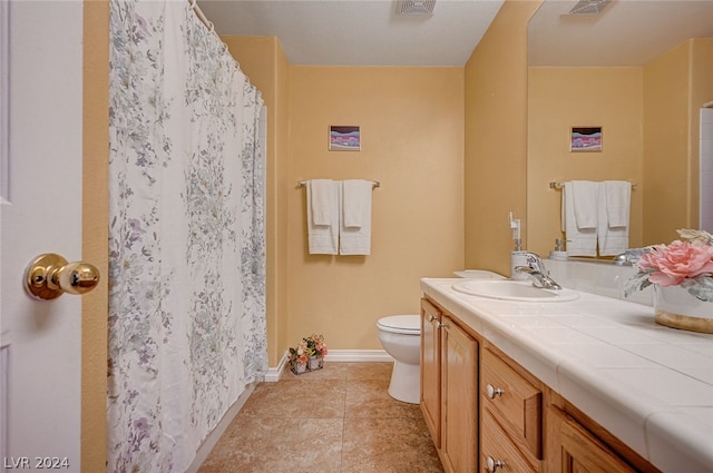 bathroom featuring vanity, tile patterned flooring, and toilet