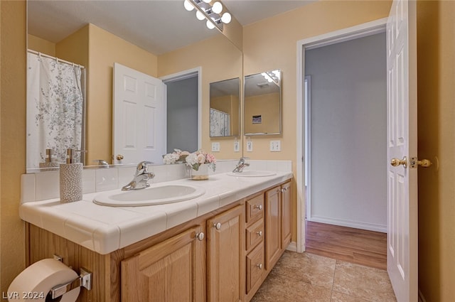 bathroom featuring hardwood / wood-style flooring and double vanity