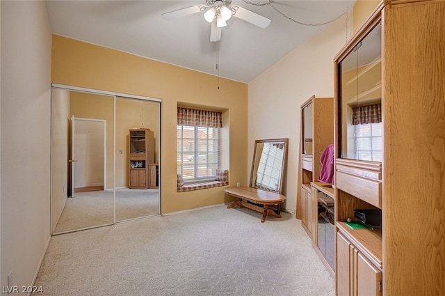 living area featuring light carpet and ceiling fan