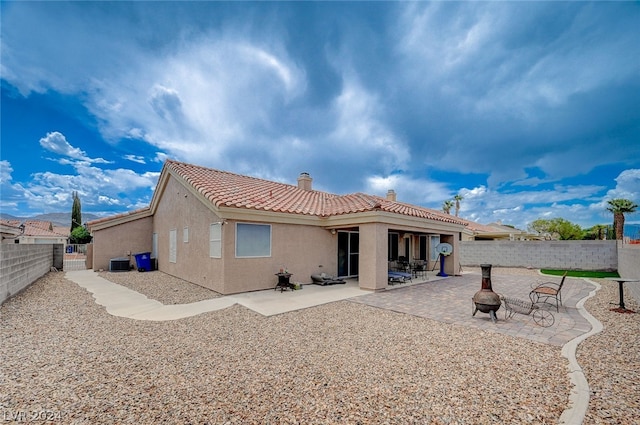 rear view of property with a patio area and central AC unit