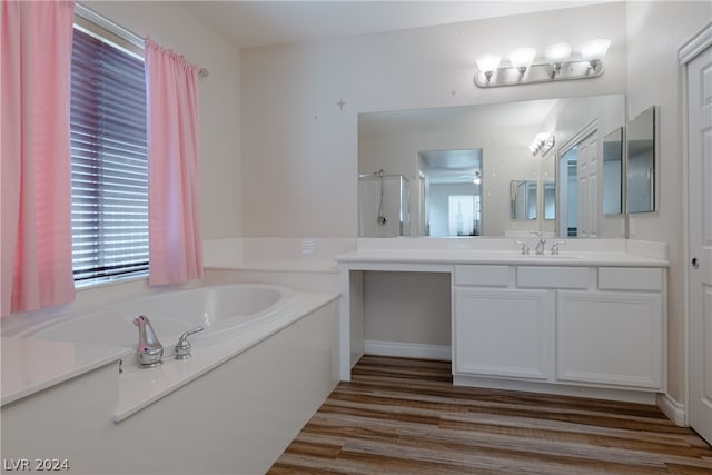 bathroom featuring independent shower and bath, hardwood / wood-style floors, and vanity