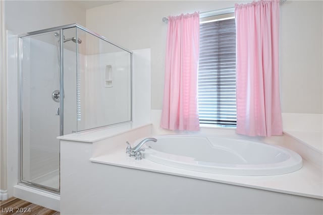 bathroom featuring separate shower and tub