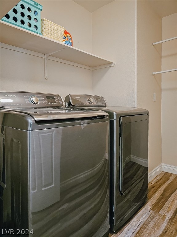 washroom with independent washer and dryer and light wood-type flooring