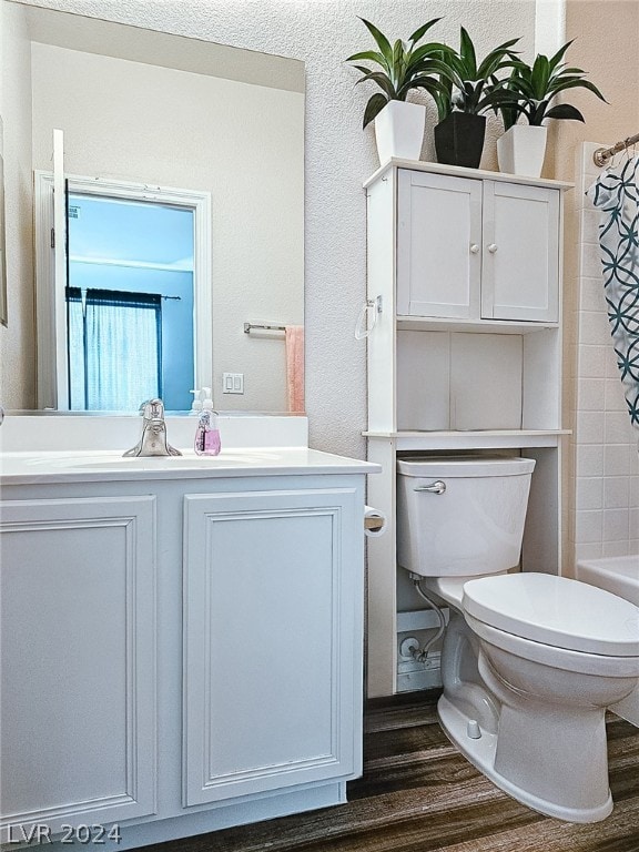 full bathroom with vanity, hardwood / wood-style flooring, and toilet