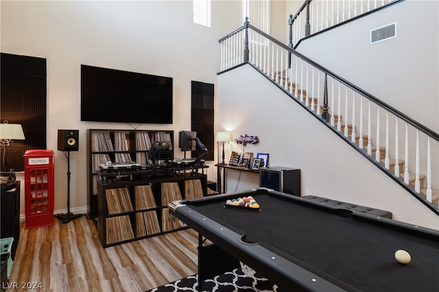 rec room with a high ceiling, hardwood / wood-style flooring, and pool table