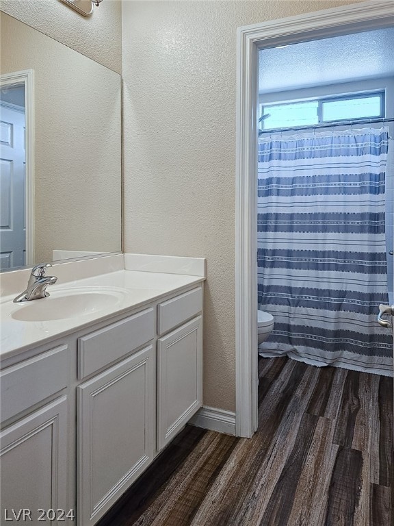 bathroom featuring hardwood / wood-style floors, vanity, a textured ceiling, and toilet