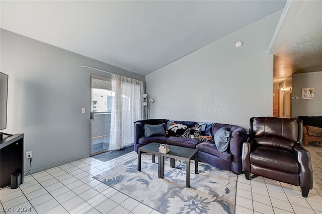 living room with a textured ceiling, lofted ceiling, and light tile patterned floors