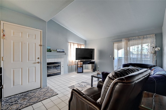 tiled living room featuring lofted ceiling and a tiled fireplace