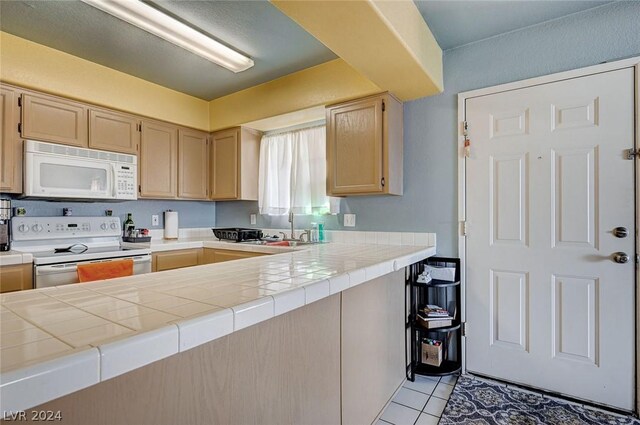 kitchen with tile counters, sink, white appliances, light brown cabinets, and light tile patterned floors