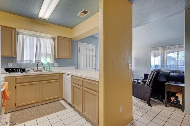 kitchen with light tile patterned floors, light brown cabinets, white dishwasher, and tile countertops