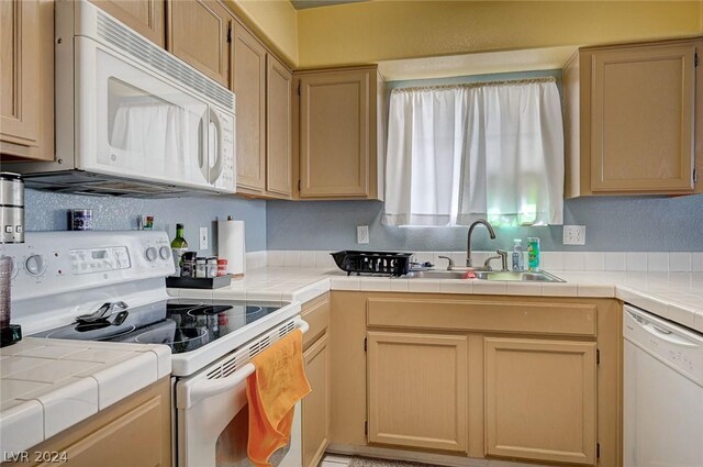 kitchen featuring tile counters, white appliances, sink, and light brown cabinets