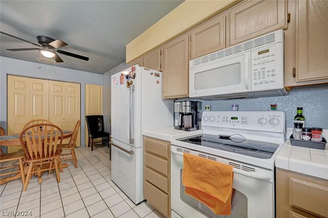 kitchen featuring ceiling fan, light brown cabinetry, tile countertops, and white appliances