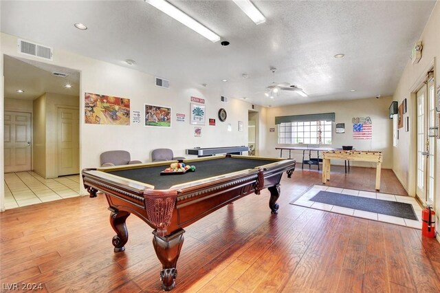 game room with ceiling fan, light hardwood / wood-style floors, billiards, and a textured ceiling