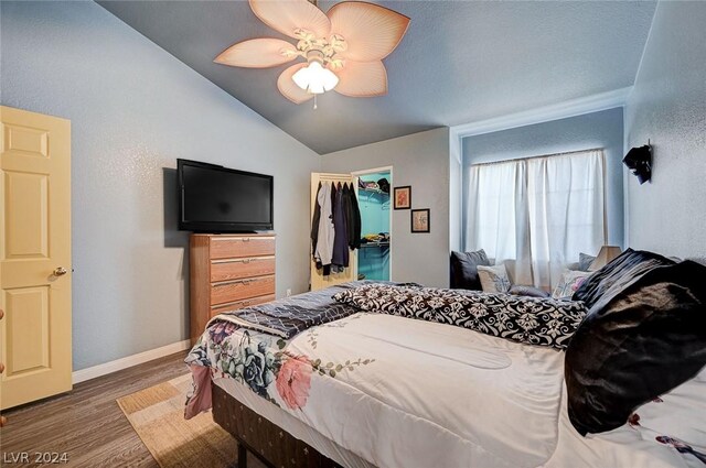 bedroom featuring ceiling fan, lofted ceiling, dark wood-type flooring, a closet, and a spacious closet