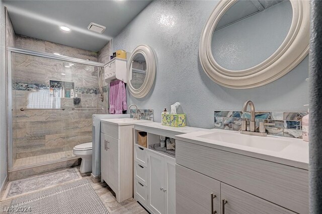 bathroom with a shower with shower door, vanity, and toilet