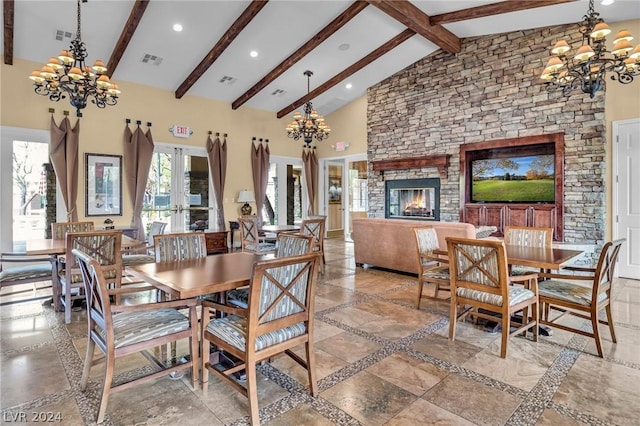 dining area featuring beam ceiling, french doors, a stone fireplace, high vaulted ceiling, and a notable chandelier