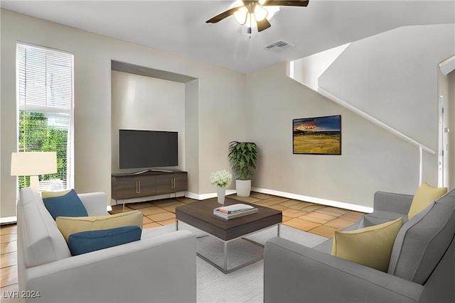 living room with ceiling fan, plenty of natural light, and light tile patterned floors