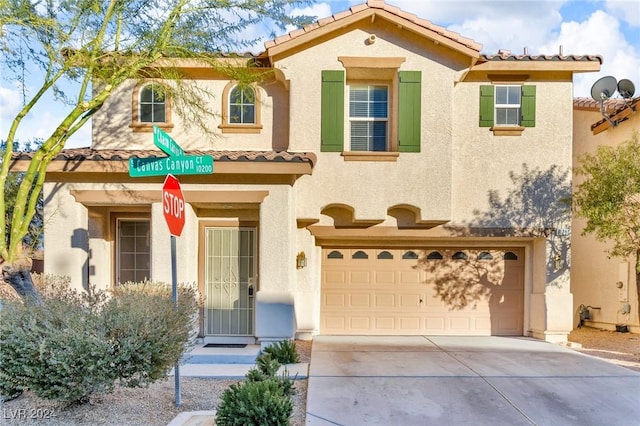 mediterranean / spanish-style home with a garage