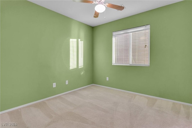 spare room featuring ceiling fan and light colored carpet