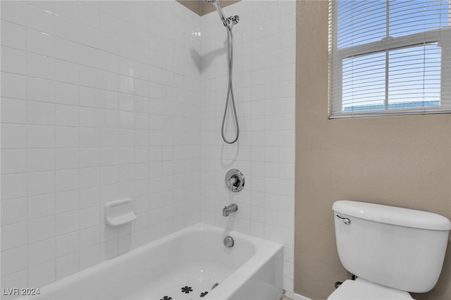 bathroom with tiled shower / bath and toilet