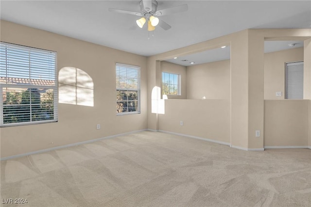 unfurnished room featuring light colored carpet and ceiling fan