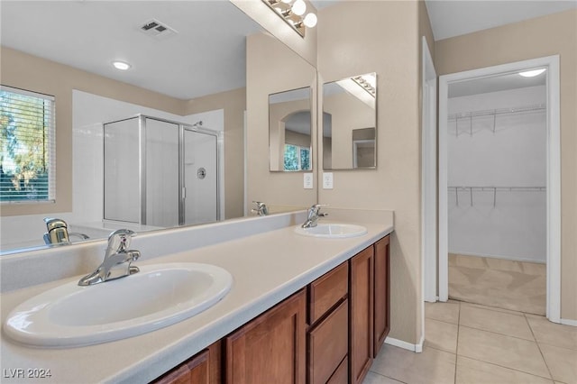 bathroom with tile patterned floors, a shower with door, and vanity