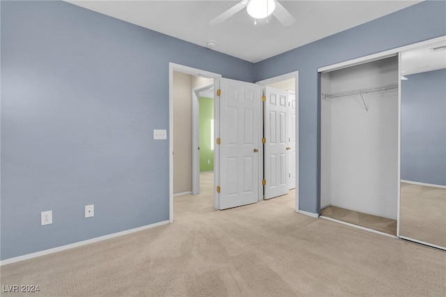 unfurnished bedroom featuring ceiling fan, a closet, and light carpet