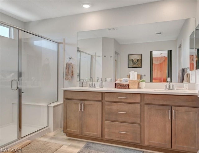 bathroom with vanity, hardwood / wood-style floors, and a shower with shower door