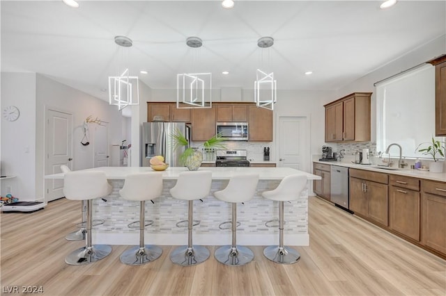 kitchen featuring stainless steel appliances, a breakfast bar area, a center island, and pendant lighting