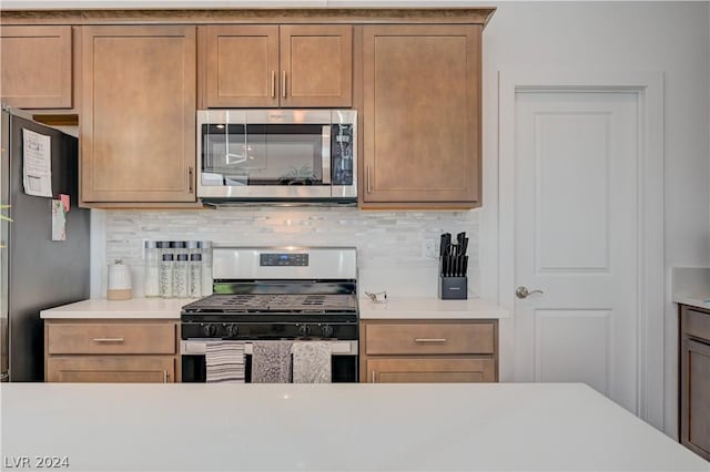 kitchen with tasteful backsplash and appliances with stainless steel finishes