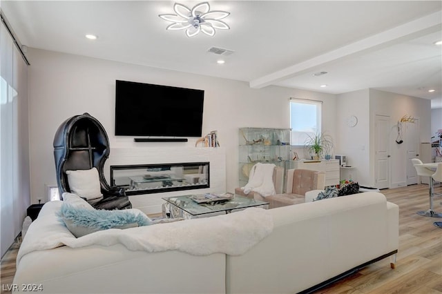 living room featuring light hardwood / wood-style floors and beamed ceiling