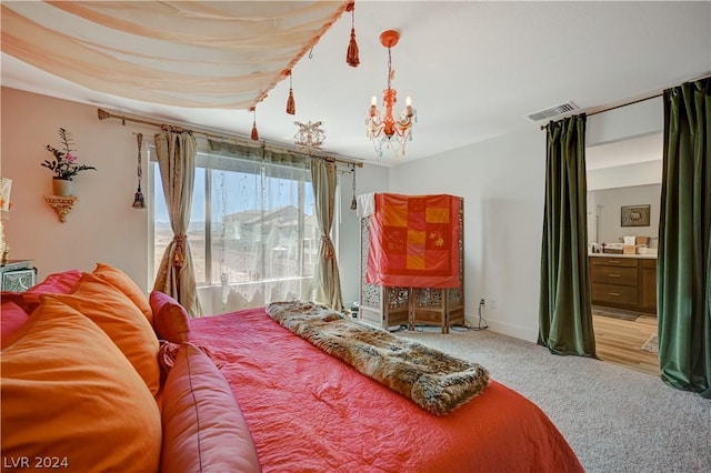 carpeted bedroom featuring ensuite bathroom and a notable chandelier