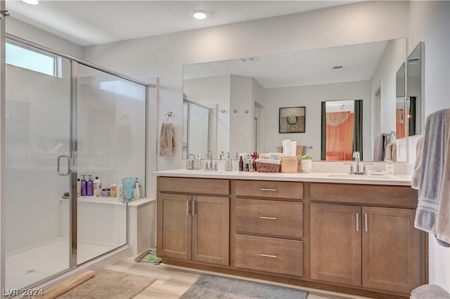 bathroom featuring walk in shower, vanity, and wood-type flooring