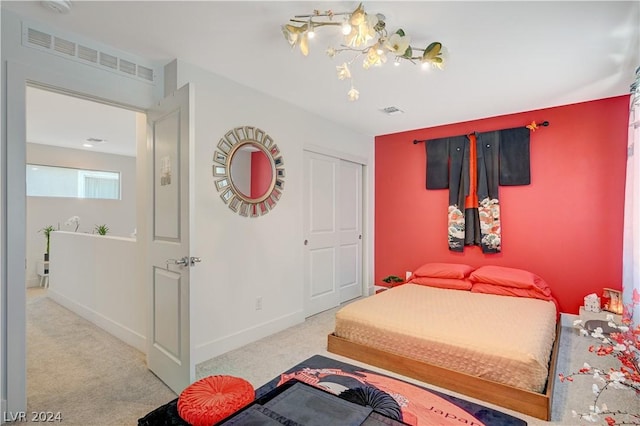 bedroom featuring an inviting chandelier, a closet, and light carpet