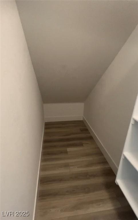 stairs with wood-type flooring and vaulted ceiling