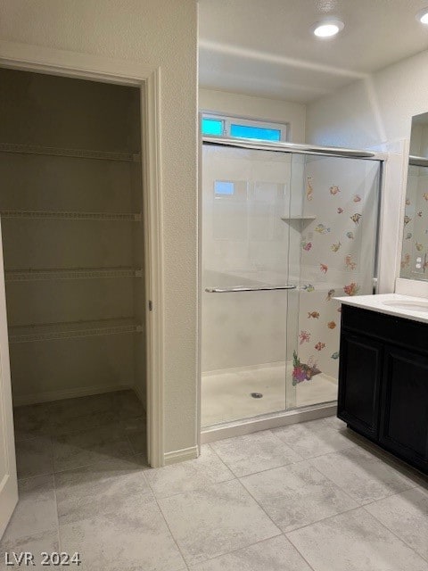 bathroom featuring vanity, an enclosed shower, and tile patterned floors