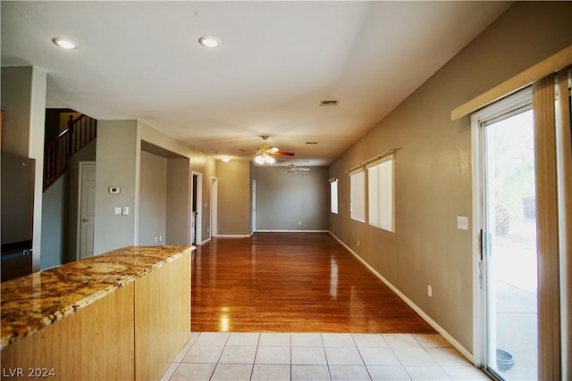 interior space with light tile patterned floors, light brown cabinetry, and ceiling fan