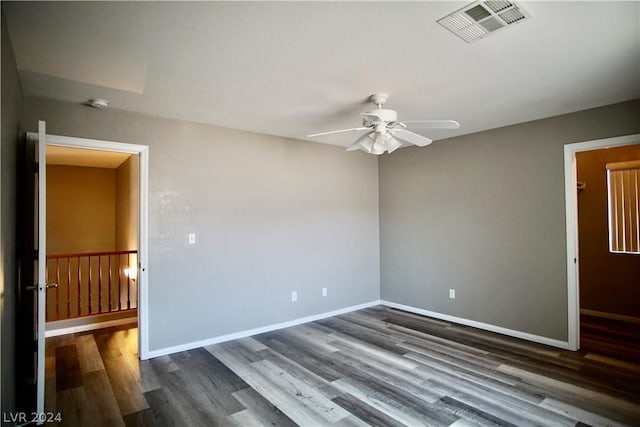 unfurnished room with dark wood-type flooring and ceiling fan