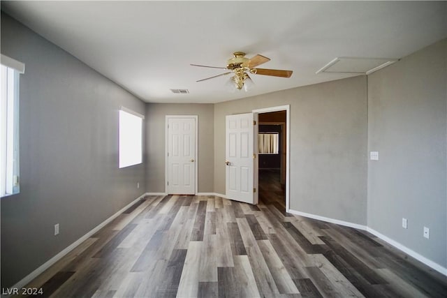 unfurnished bedroom with ceiling fan and dark hardwood / wood-style flooring