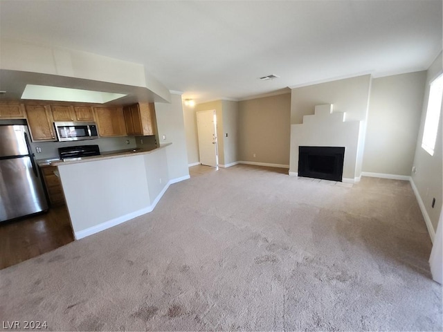 kitchen featuring appliances with stainless steel finishes, carpet flooring, and kitchen peninsula