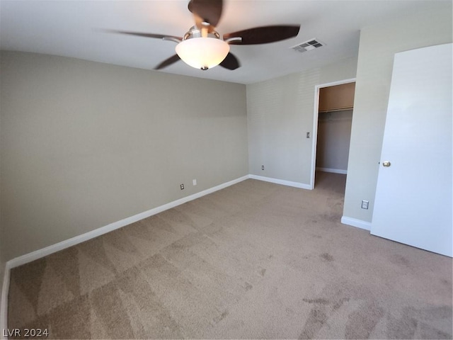 unfurnished bedroom with light colored carpet, a closet, and ceiling fan