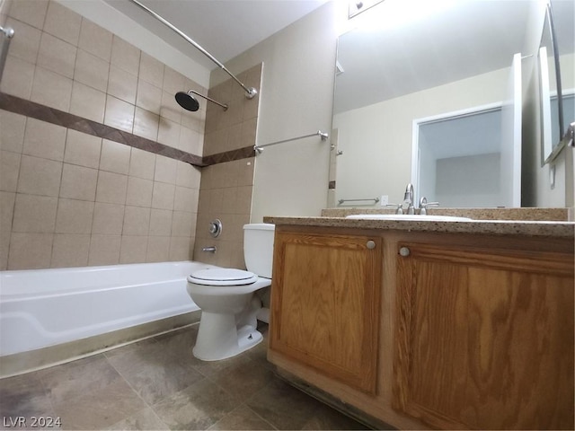 full bathroom featuring vanity, tiled shower / bath, and toilet