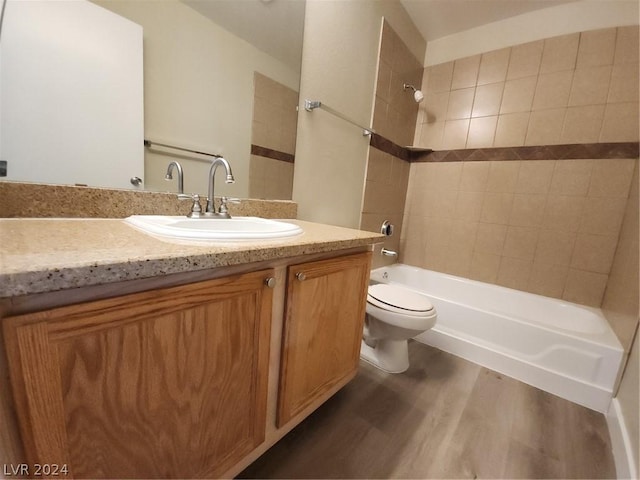 full bathroom featuring vanity, hardwood / wood-style flooring, toilet, and tiled shower / bath