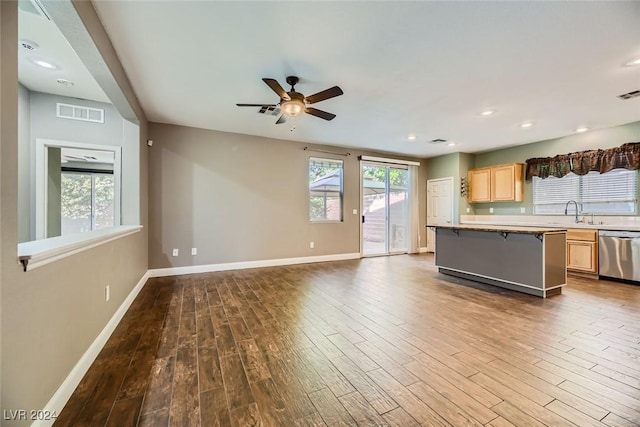 kitchen with hardwood / wood-style flooring, dishwasher, a kitchen breakfast bar, a wealth of natural light, and light brown cabinets