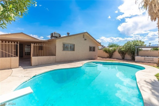 view of pool featuring a diving board and a patio