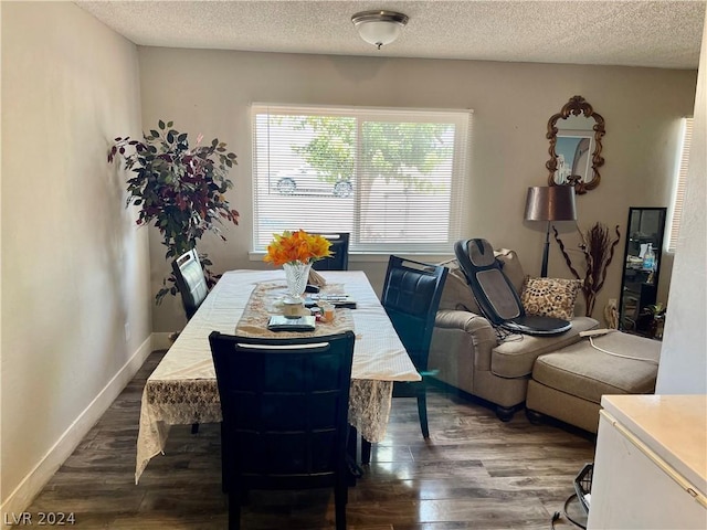 dining area with dark hardwood / wood-style floors and a textured ceiling