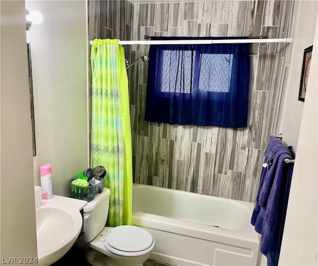 full bathroom featuring sink, shower / tub combo with curtain, and toilet