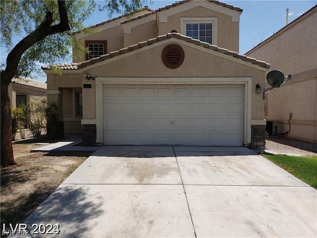 view of front facade featuring a tile roof, an attached garage, driveway, and stucco siding