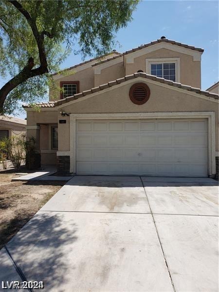 view of front facade featuring stucco siding, concrete driveway, and a tile roof